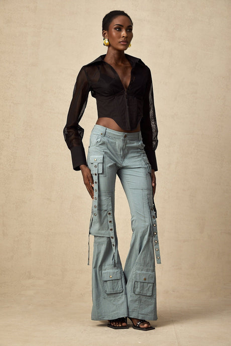 Woman wearing green flared cargo trousers with belt loops and multiple pockets standing in casual pose