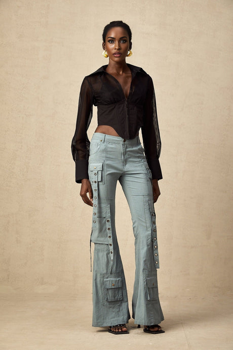 Woman wearing green flared cargo trousers with belt loops and multiple pockets standing in casual pose