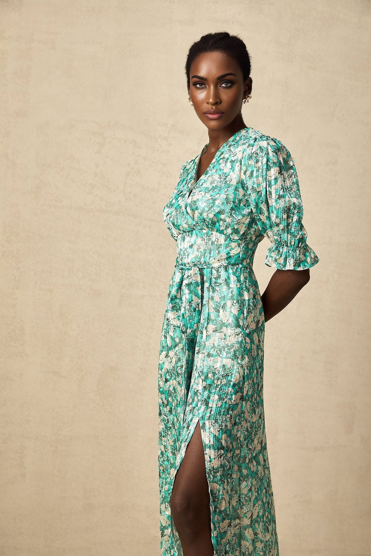 Woman wearing green midi dress with floral print and high slit