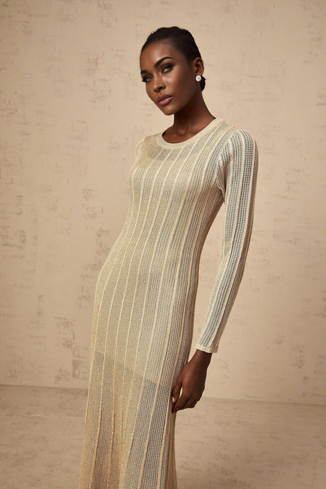 Woman wearing khaki colored fitted knit midi dress with long sleeves standing against plain background