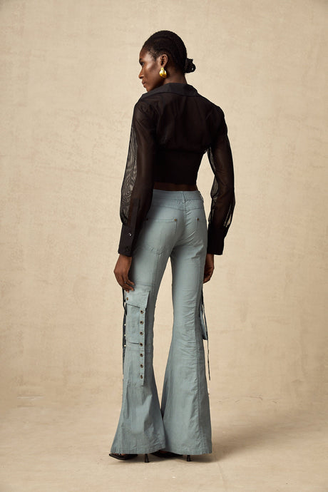 Woman wearing khaki flared cargo trousers with belt loops and multiple pockets standing in relaxed pose