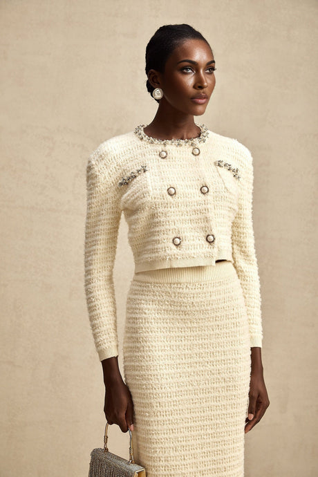 Woman wearing matching knit cardigan and skirt set with embellishments named Justine