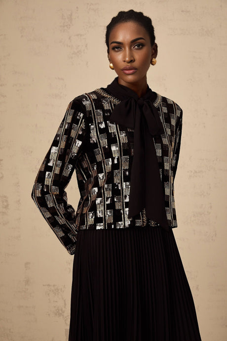 Woman wearing matching sequined cardigan and dress set in checkered pattern