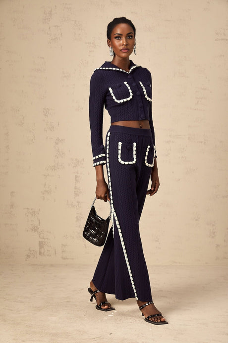 Woman wearing navy blue crochet knit cardigan and matching trousers set by Elvira
