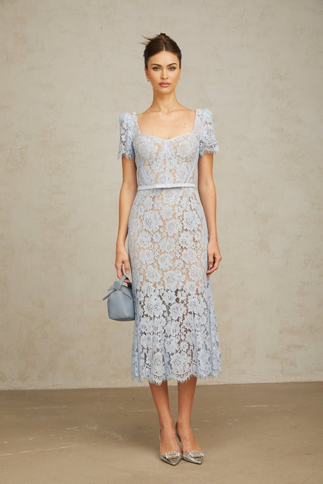Woman wearing sleeveless blue midi dress with floral lace pattern and boned bodice