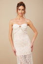 Woman wearing white lace midi dress with crystal embellished bustier top and fitted silhouette