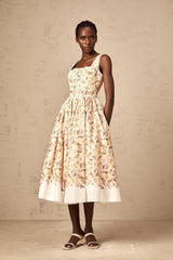Woman wearing yellow midi dress with floral print and button details