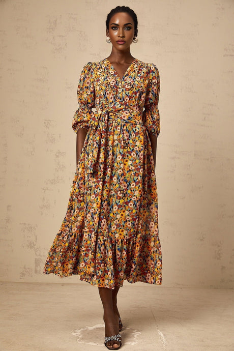 Woman wearing yellow midi dress with Vneck and floral print pattern standing in relaxed pose