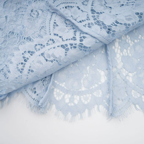 Young woman wearing a blue midi dress with floral lace pattern and boned bodice