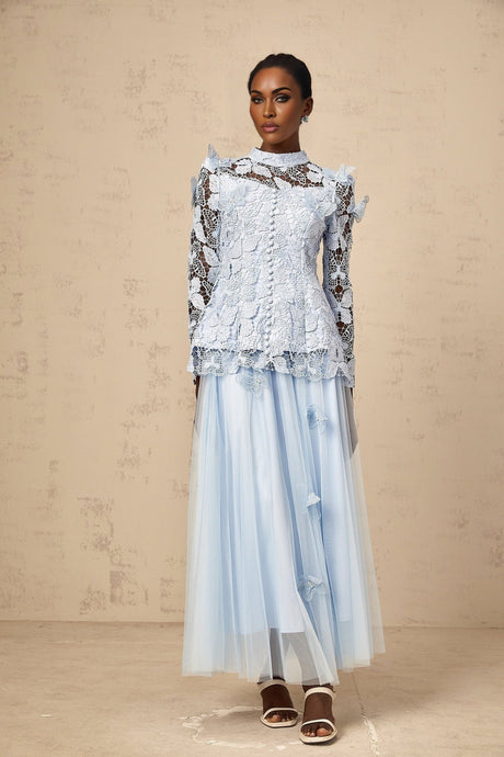 Young woman wearing a blue sequined lace top and matching skirt set with sparkling details