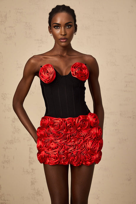 Young woman wearing a red matching set consisting of a top and skirt with rose applique details