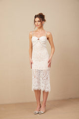 Young woman wearing a white lace midi dress with crystal embellished bustier top and form fitting silhouette